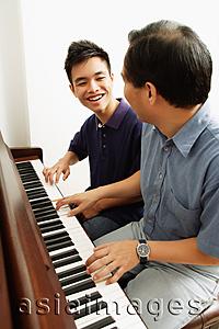 Asia Images Group - Father and son playing piano, side by side