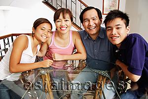 Asia Images Group - Family at home, sitting side by side, looking at camera