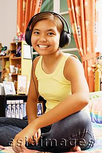 Asia Images Group - Young woman wearing headphones, looking at camera
