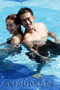 Asia Images Group -  Couple in swimming pool, looking at camera
