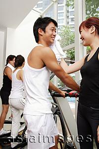 Asia Images Group - Couple in gym, woman wiping man's face