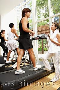 Asia Images Group - Young adults in gym, walking on treadmill