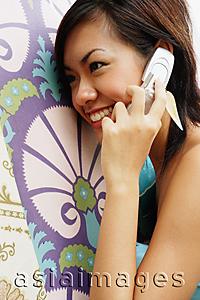 Asia Images Group - Young woman using mobile phone, sideview