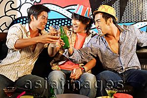 Asia Images Group - Three young men, at entertainment club, toasting
