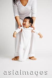 Asia Images Group - Baby boy standing, mother behind him holding his arms