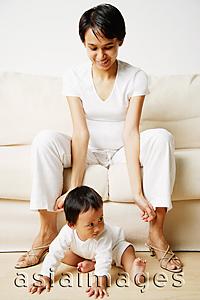 Asia Images Group - Mother sitting on sofa, baby boy sitting on floor