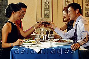 Asia Images Group - Couples in restaurant, raising wine glasses for a toast