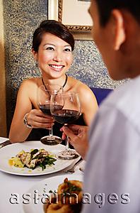Asia Images Group - Couple in restaurant toasting with wine glasses