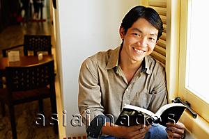 Asia Images Group - Man holding book, smiling