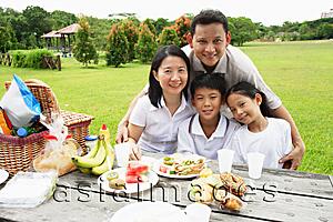 Asia Images Group - Family sitting at picnic table, looking at camera, portrait