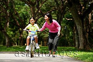 Asia Images Group - Girl on bicycle, mother walking next to her