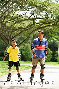 Asia Images Group - Father and son in park, on roller blades