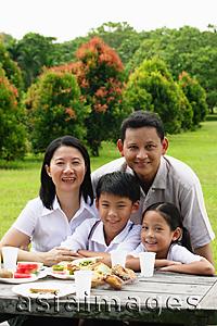 Asia Images Group - Family seated at picnic table, portrait