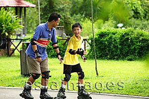 Asia Images Group - Father and son on roller blades