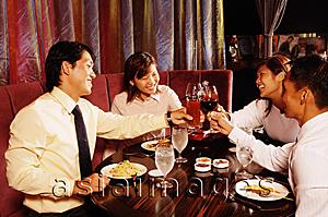 Asia Images Group - Couples sitting at restaurant, toasting with drinks across table