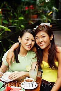 Asia Images Group - Two women, one with arm around the other, looking at camera