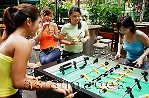 Asia Images Group - Young women playing foosball