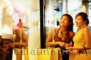 Asia Images Group - Young women looking at window display, pointing