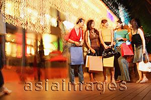 Asia Images Group - Young women standing side by side, carrying shopping bags