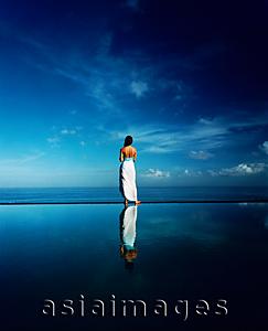 Asia Images Group - Asian female standing along edge of horizon pool