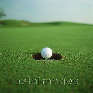Asia Images Group - Golf ball dropping in to hole
