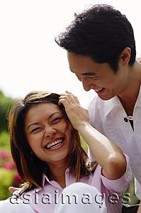 Asia Images Group - Couple laughing, woman touching her hair