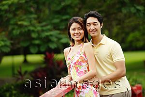 Asia Images Group - Couple standing side by side, smiling at camera, portrait