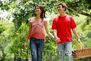 Asia Images Group - Couple holding hands, man carrying picnic basket