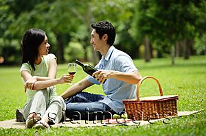 Asia Images Group - Couple in park, man pouring wine for woman, portrait
