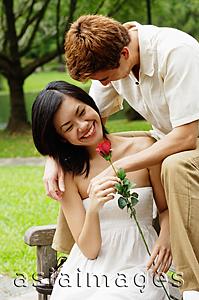 Asia Images Group - Couple on park bench, woman holding a rose