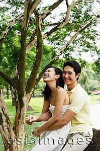 Asia Images Group - Woman sitting on mans lap, man embracing her, both smiling