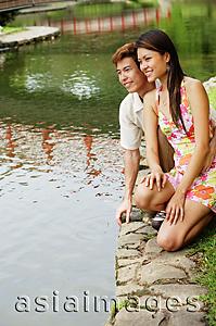 Asia Images Group - Couple crouching next to pond edge