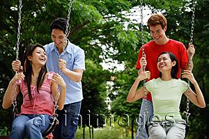 Asia Images Group - Women on swings, men standing behind them, pushing swings