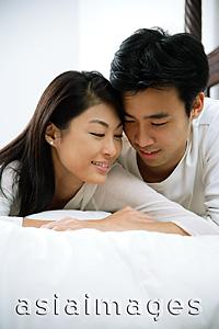 Asia Images Group - Couple lying in bed, side by side, cheek to cheek