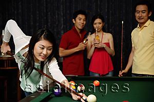 Asia Images Group - Woman playing snooker, people watching