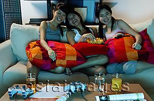 Asia Images Group - Three young women in living room, watching TV