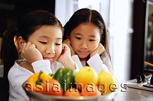 Asia Images Group - Children staring at a bowl of vegetables