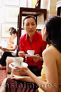 Asia Images Group - Women sitting, talking, holding cups and saucers