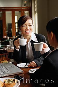Asia Images Group - Two businesswomen at cafe, drinking coffee