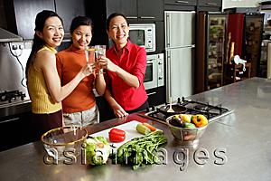Asia Images Group - Women in kitchen, toasting, smiling at camera