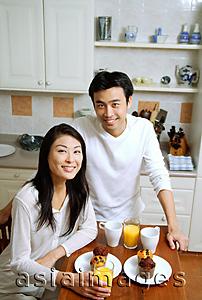 Asia Images Group - Couple having breakfast, smiling at camera