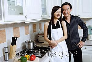 Asia Images Group - Couple standing in kitchen, smiling at camera