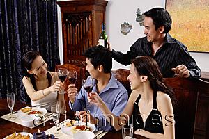 Asia Images Group - Adults at dining table toasting with wine glasses