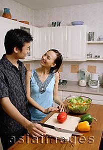 Asia Images Group - Couple in kitchen, smiling at each other