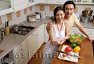 Asia Images Group - Couple in kitchen, smiling at camera, portrait