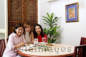 Asia Images Group - Three women sitting at a restaurant with food on table