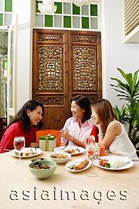 Asia Images Group - Three women in restaurant, talking and laughing