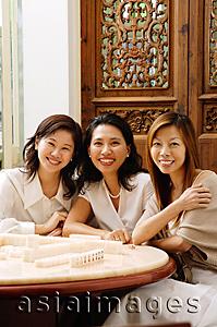 Asia Images Group - Three women sitting side by side, smiling