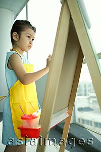 Asia Images Group - Young girl wearing apron, standing in front of easel, painting