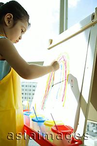 Asia Images Group - Young girl with apron, painting a rainbow
